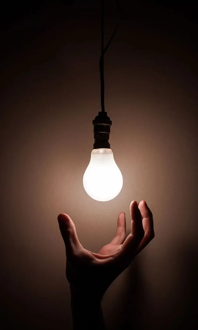 Foco encendido con una mano debajo